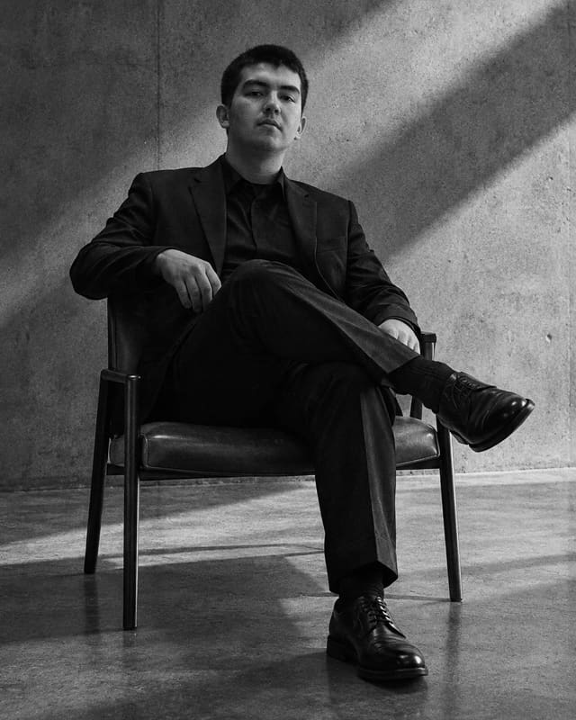 Gerardo Gonzalez Castillo, fundador de Verssatil, sentado en un sillón frente a un muro de hormigón